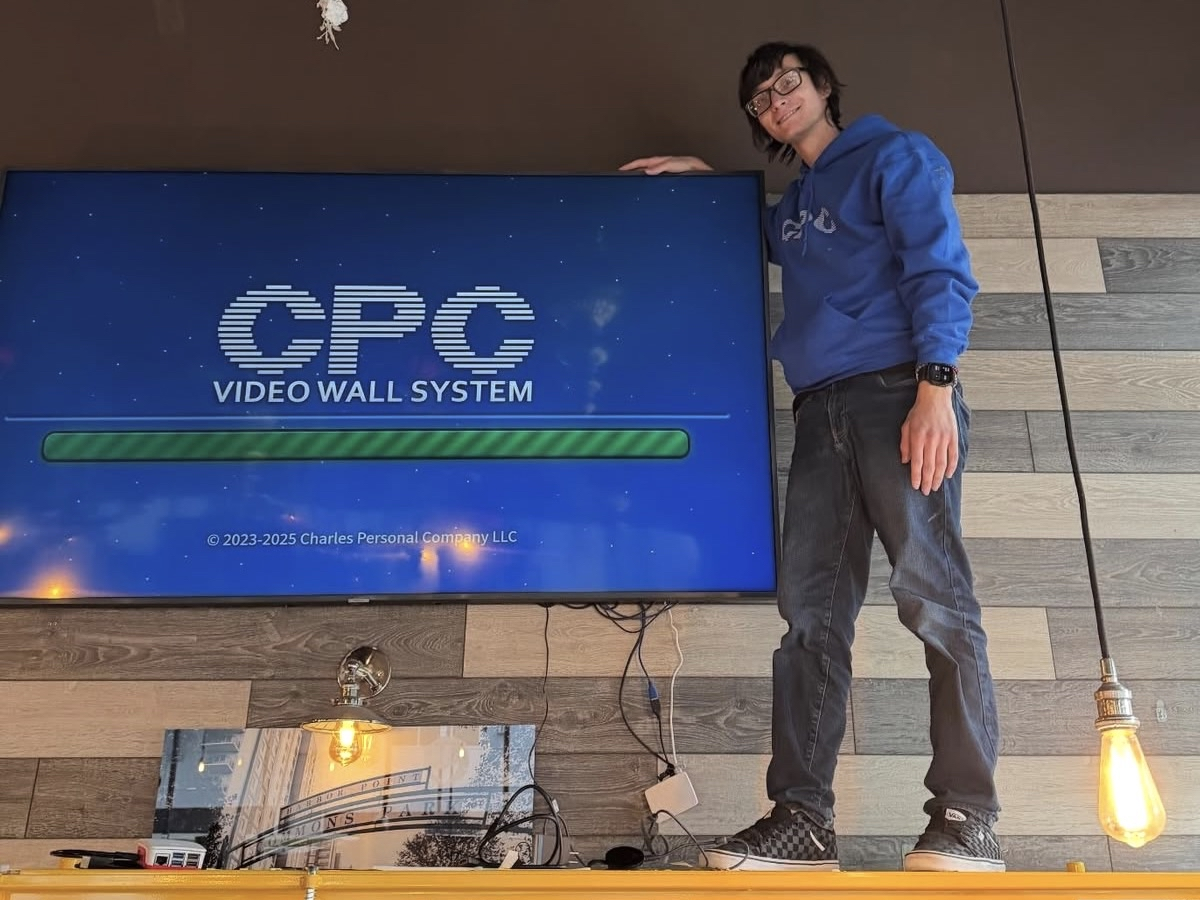 Section image - Our CEO Charles standing next to a Video Wall